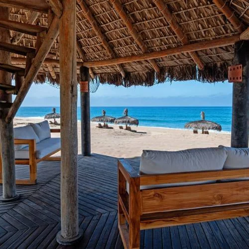 Private Beachfront Hotel Thatched roof huts at the private beach resort, Villa Santa Cruz in Todos Santos